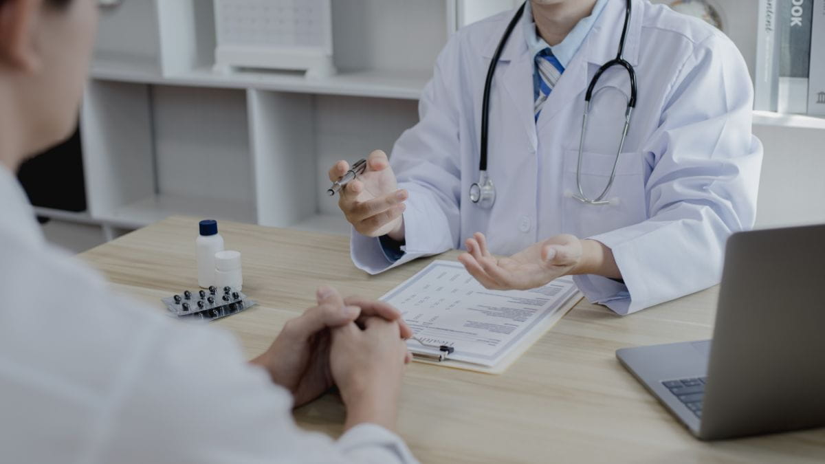 Dokter legt aan een patiënt uit hoe de terugbetaling van het remgeld en de medische kosten werken