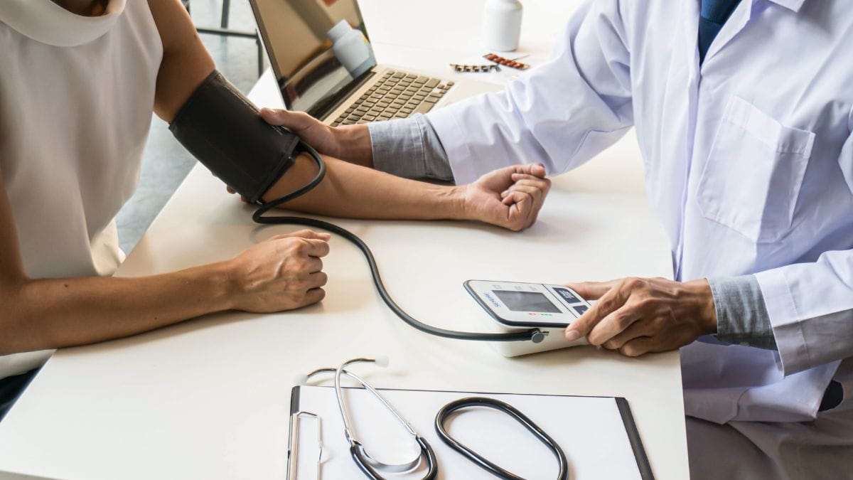 Arts die de bloeddruk meet bij een patiënt tijdens een consultatie gedekt door de hospitalisatieverzekering van Ethias