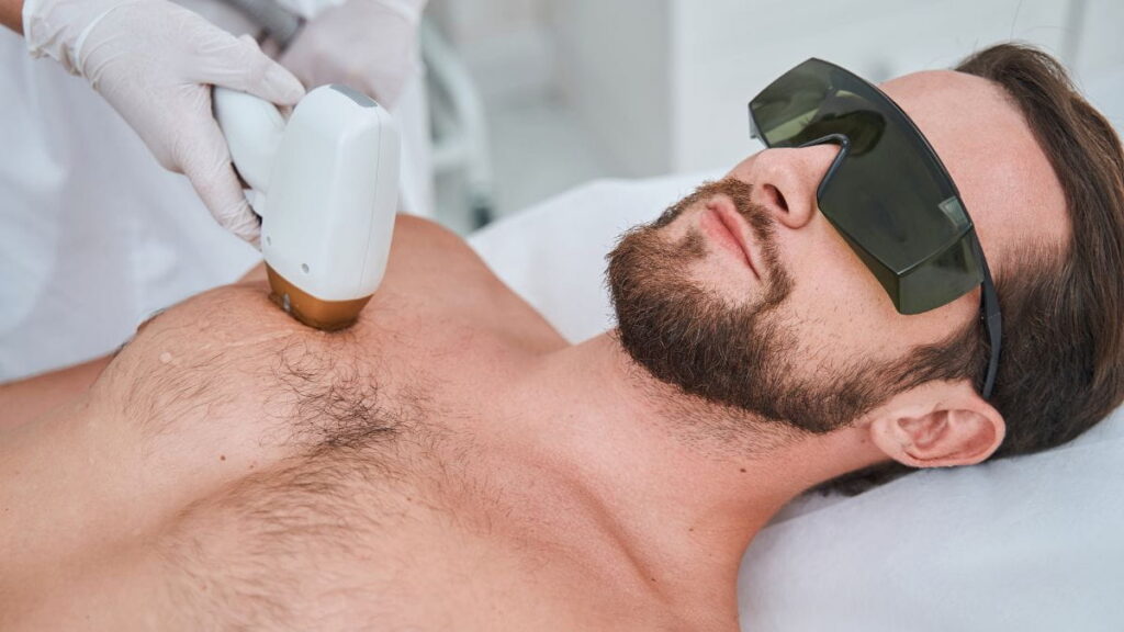 Man met beschermbril krijgt een laserbehandeling op de borst voor definitieve ontharing