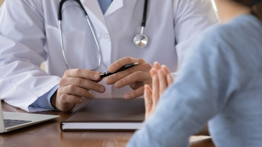 Huisarts bespreekt de terugbetaling met een patiënt tijdens een consultatie