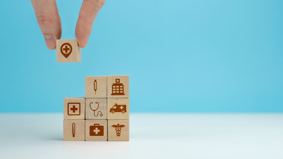 Houten blokken met medische iconen die de verschillende terugbetalingen van een ziekenfonds voorstellen