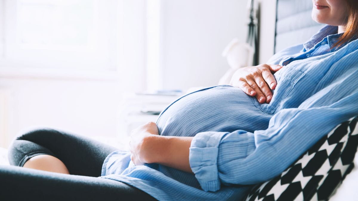 Zwangere vrouw rust op de zetel en bereidt zich voor op haar moederschapsrust uitkering